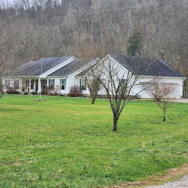 view of front of house with a porch, a front yard, and a garage