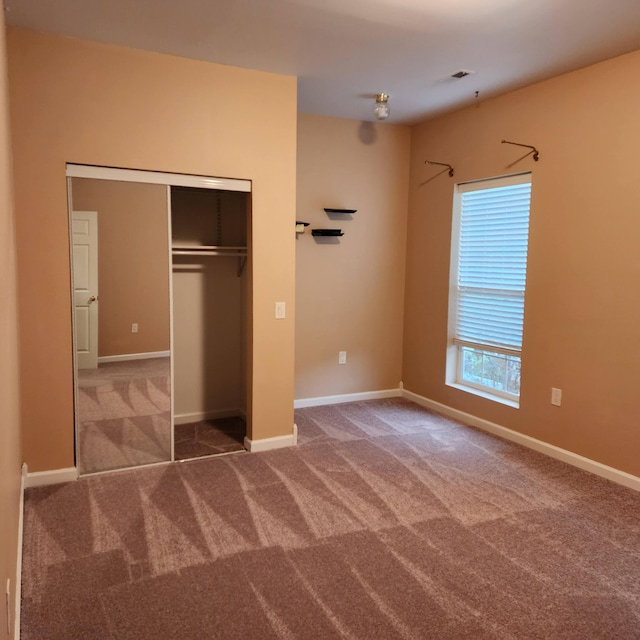 unfurnished bedroom featuring carpet flooring and a closet