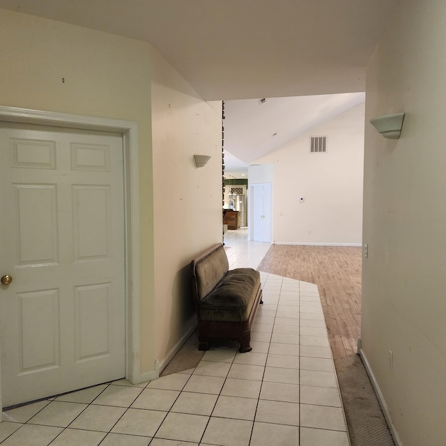 laundry room featuring electric panel, cabinets, light tile patterned flooring, and stacked washing maching and dryer