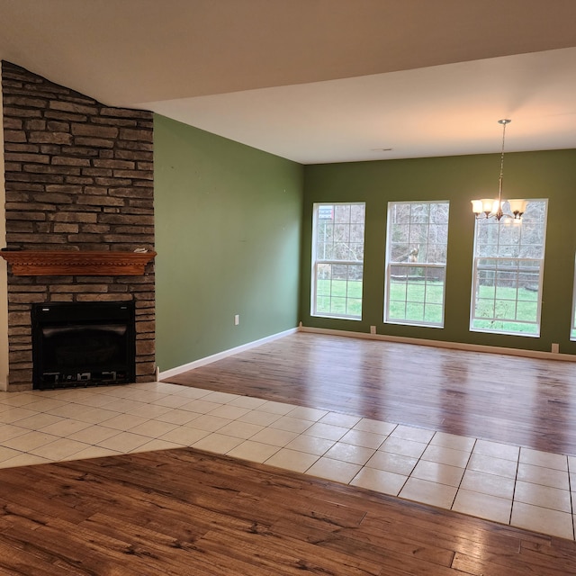 unfurnished living room featuring light hardwood / wood-style floors, a fireplace, and a chandelier