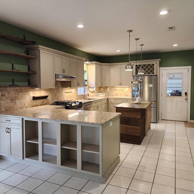 kitchen with kitchen peninsula, backsplash, stainless steel appliances, sink, and pendant lighting