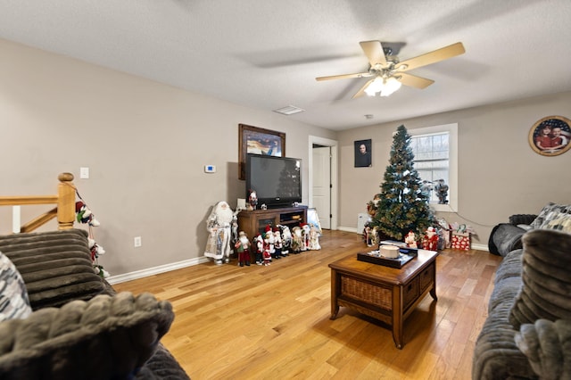 living room featuring hardwood / wood-style floors, a textured ceiling, and ceiling fan