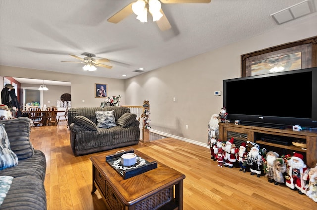 living room featuring hardwood / wood-style floors, a textured ceiling, and ceiling fan