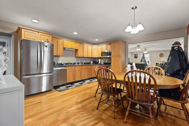 kitchen with pendant lighting, light brown cabinets, stainless steel appliances, and light hardwood / wood-style flooring