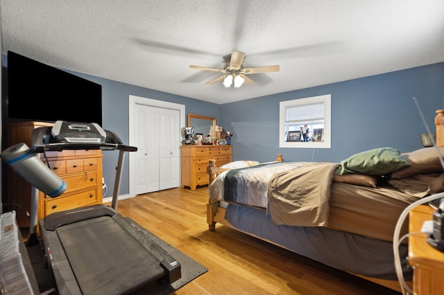 bedroom with ceiling fan, a closet, a textured ceiling, and hardwood / wood-style flooring