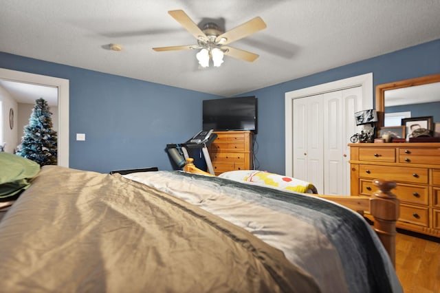 bedroom featuring ceiling fan, a closet, a textured ceiling, and hardwood / wood-style flooring