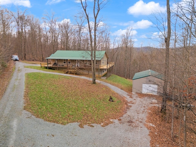 view of yard with a porch, a garage, and an outdoor structure