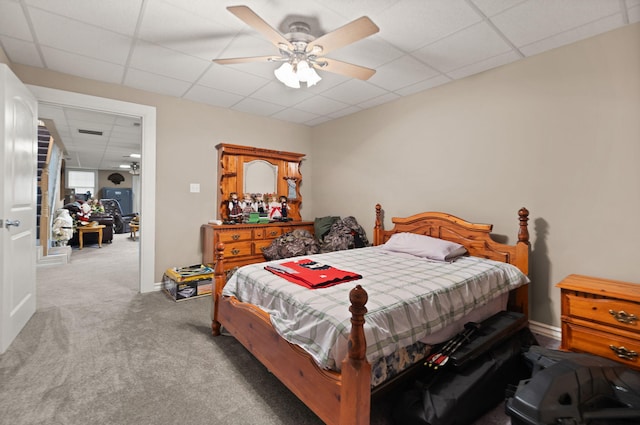 carpeted bedroom featuring ceiling fan and a drop ceiling