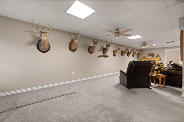 interior space with carpet, a drop ceiling, and ceiling fan