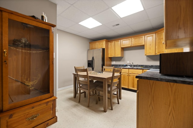 kitchen with stainless steel fridge, a paneled ceiling, and sink