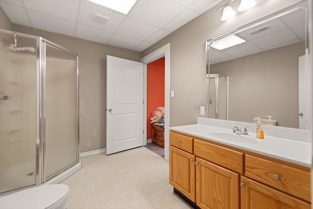 bathroom with a paneled ceiling, vanity, and an enclosed shower