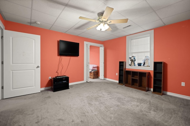 interior space with carpet flooring, ceiling fan, and a drop ceiling