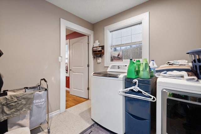 laundry room featuring washer and clothes dryer and light hardwood / wood-style flooring