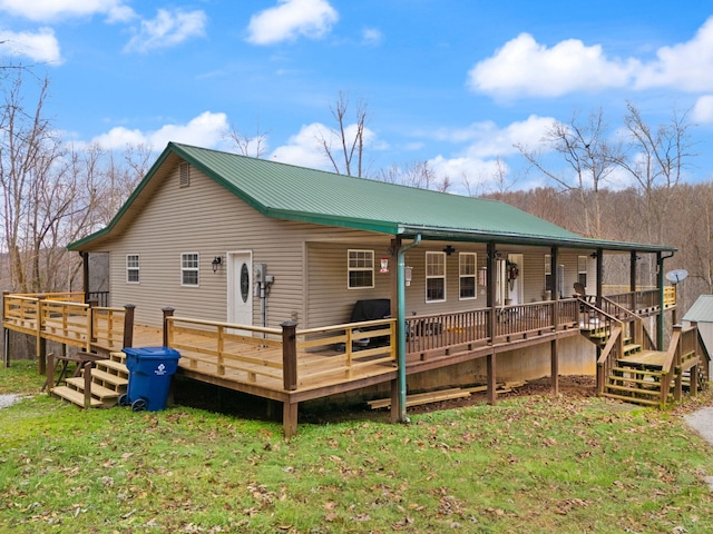 rear view of house featuring a lawn and a deck