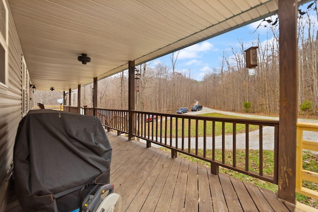 wooden terrace featuring a porch and a grill