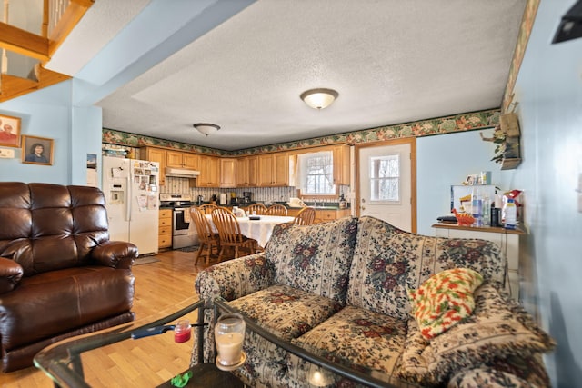 living room featuring a textured ceiling and light wood-type flooring