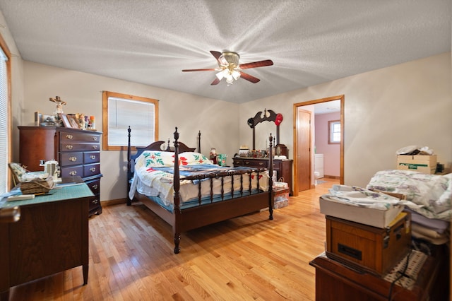 bedroom featuring a textured ceiling, light hardwood / wood-style floors, ceiling fan, and ensuite bathroom