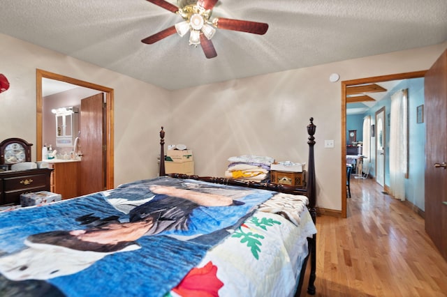 bedroom with a textured ceiling, light hardwood / wood-style floors, and ceiling fan