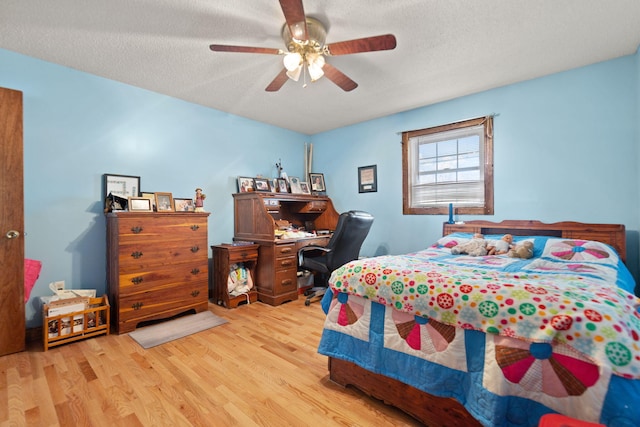 bedroom featuring ceiling fan, light hardwood / wood-style flooring, and a textured ceiling