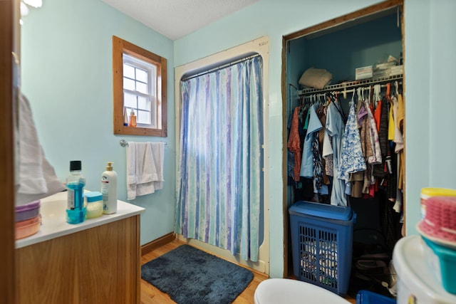 bathroom with a textured ceiling, hardwood / wood-style flooring, and walk in shower