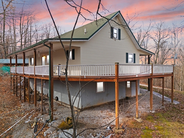 back house at dusk featuring a wooden deck