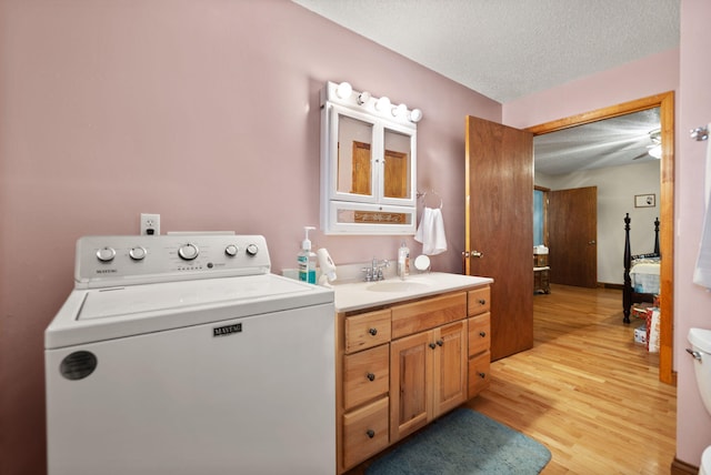 bathroom featuring vanity, toilet, a textured ceiling, washer / dryer, and wood-type flooring