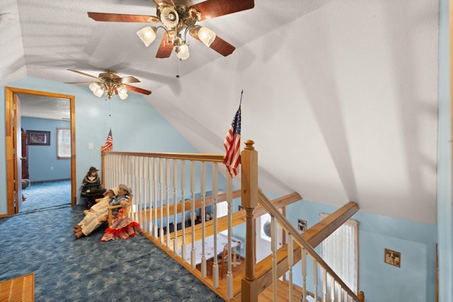 corridor featuring lofted ceiling, carpet floors, and a textured ceiling