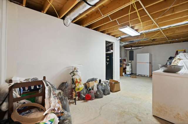 basement with electric panel and white fridge