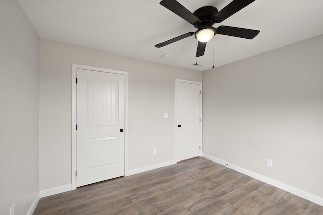 unfurnished bedroom featuring ceiling fan, a closet, baseboards, and wood finished floors