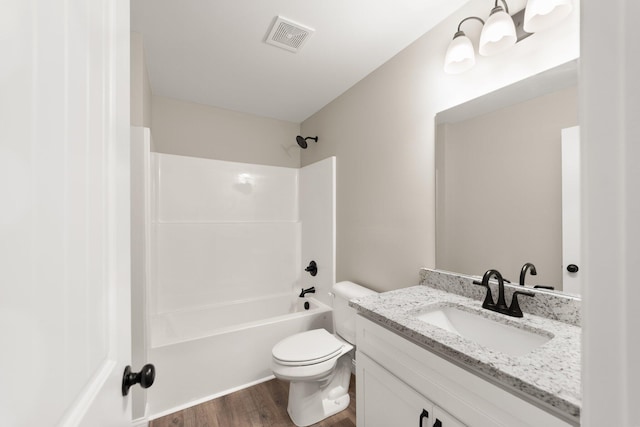 full bath featuring visible vents, toilet, tub / shower combination, vanity, and wood finished floors