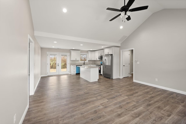 unfurnished living room with sink, hardwood / wood-style flooring, high vaulted ceiling, and ceiling fan