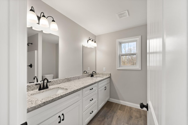 full bath featuring toilet, a sink, visible vents, and baseboards