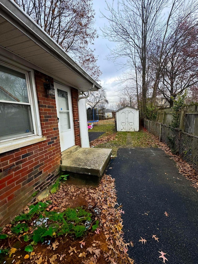 view of yard featuring a storage unit and a trampoline