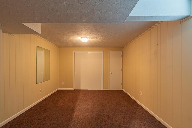 interior space with a textured ceiling and wooden walls