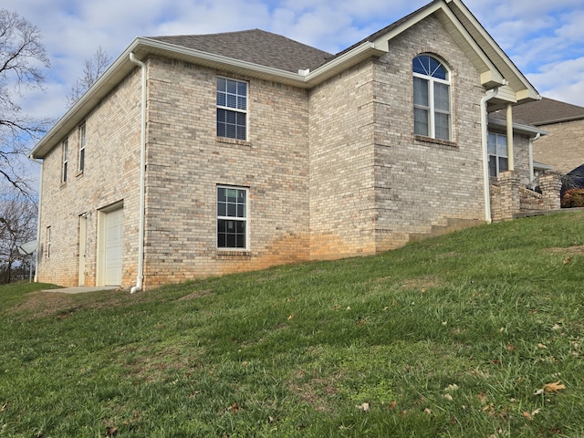 view of side of home with a yard and a garage