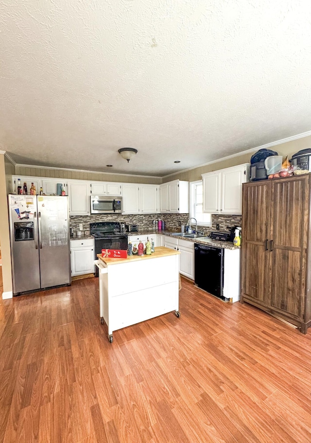 kitchen with sink, white cabinets, black appliances, and light hardwood / wood-style floors