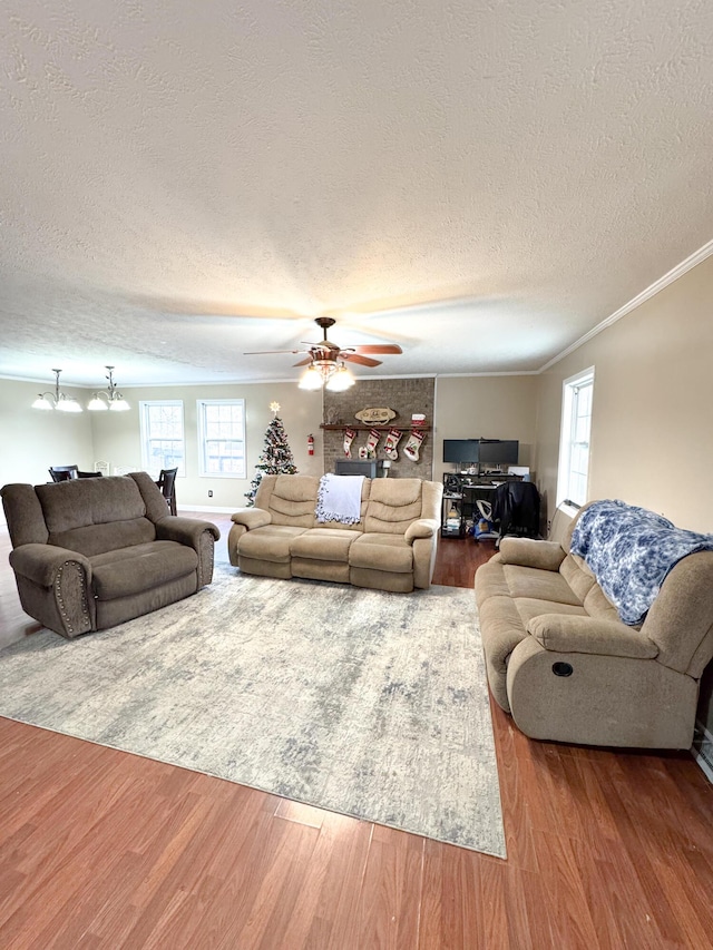 living room with crown molding, hardwood / wood-style floors, ceiling fan, and a textured ceiling