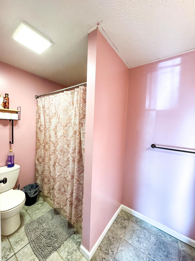 bathroom with a textured ceiling and toilet