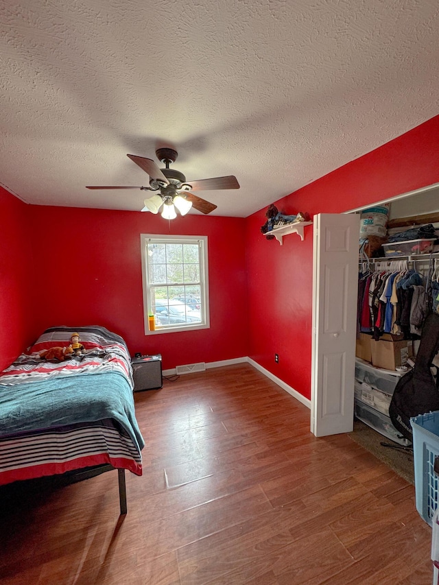 bedroom featuring a closet, a textured ceiling, hardwood / wood-style flooring, and ceiling fan