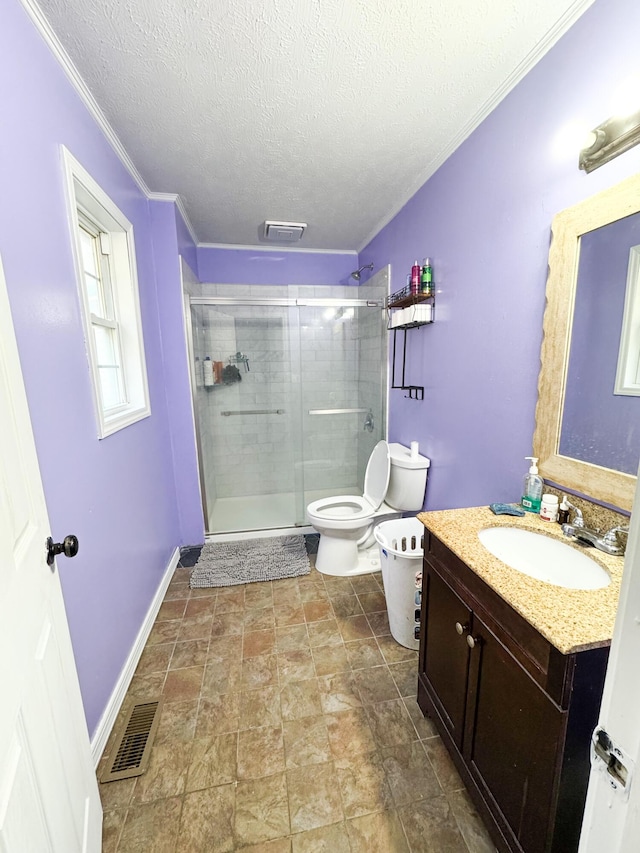 bathroom featuring a textured ceiling, toilet, a shower with door, vanity, and ornamental molding