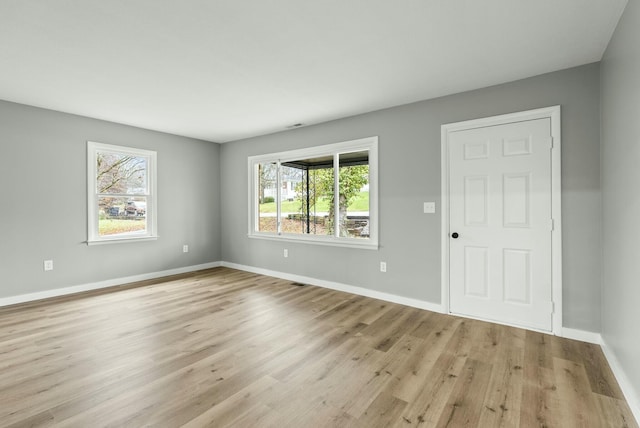 unfurnished room with plenty of natural light and light hardwood / wood-style floors