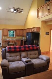 living room with light hardwood / wood-style floors, high vaulted ceiling, and ceiling fan