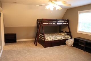 carpeted bedroom with ceiling fan and lofted ceiling