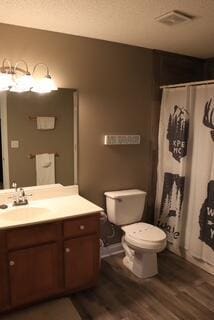 bathroom with curtained shower, toilet, vanity, and hardwood / wood-style flooring