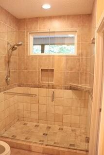 bathroom featuring walk in shower, toilet, and plenty of natural light