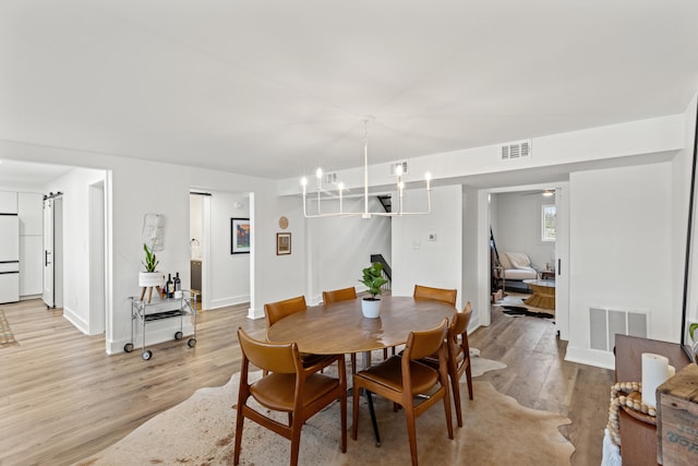 dining room with a chandelier and light hardwood / wood-style flooring