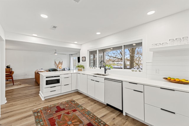 kitchen with white cabinets, white appliances, light hardwood / wood-style flooring, and sink