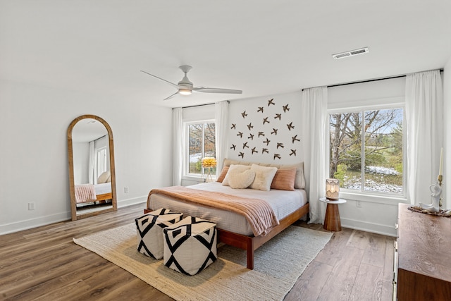 bedroom featuring multiple windows, ceiling fan, and hardwood / wood-style floors