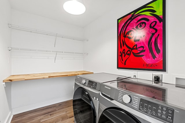 laundry room with wood-type flooring and washing machine and clothes dryer