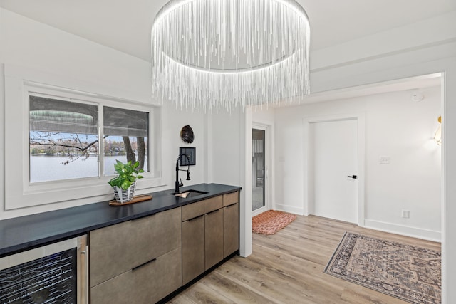 kitchen with a chandelier, light hardwood / wood-style flooring, wine cooler, and sink